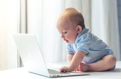 child pressing keys on a computer