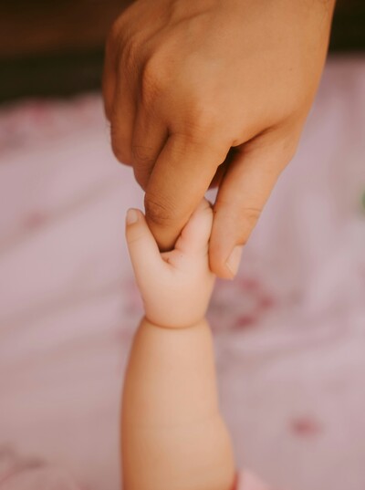 Baby holding moms hand